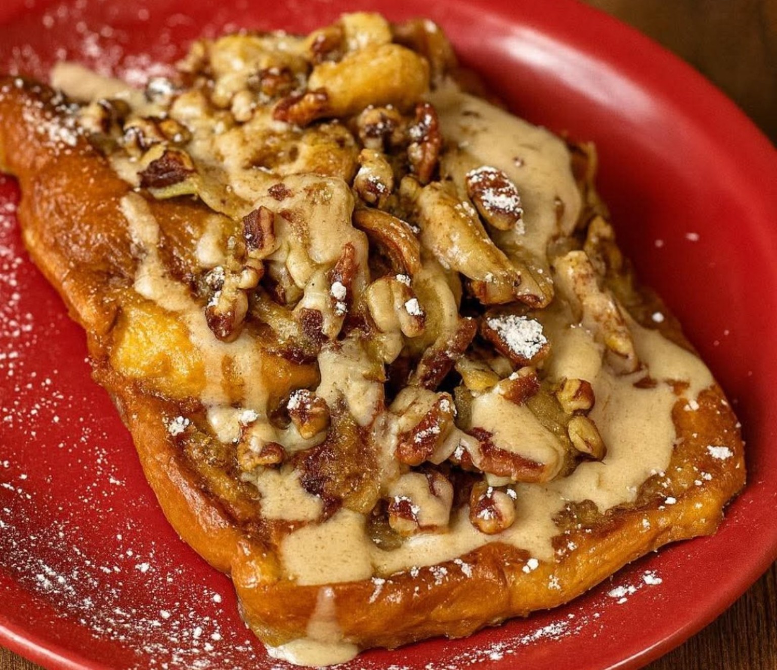 French toast topped with sauce, nuts, and powdered sugar