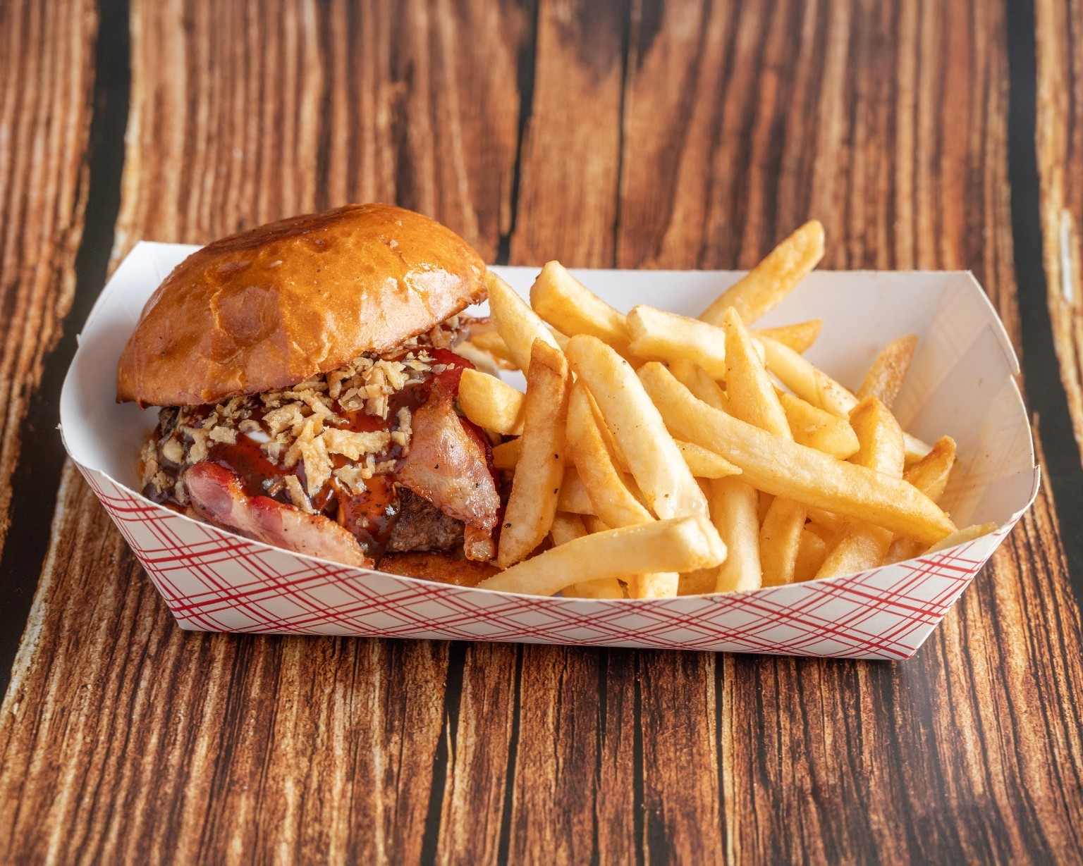 A burger with toppings beside a serving of fries